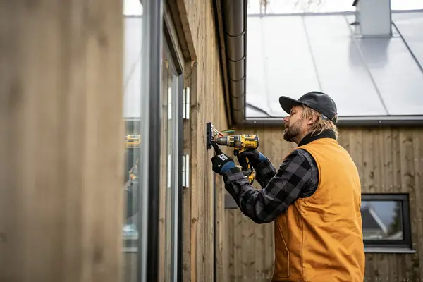 Artisan en intervention sur un bardage bois