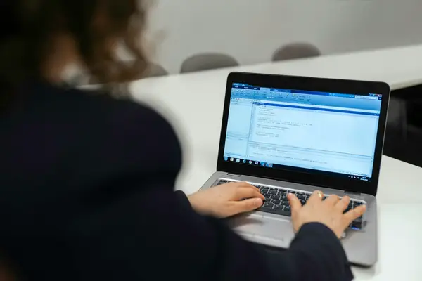 Collaboratrice travaillant sur un ancien logiciel de gestion